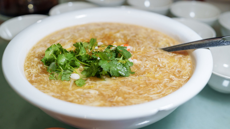 Bowl of shark fin soup with fresh herb garnish
