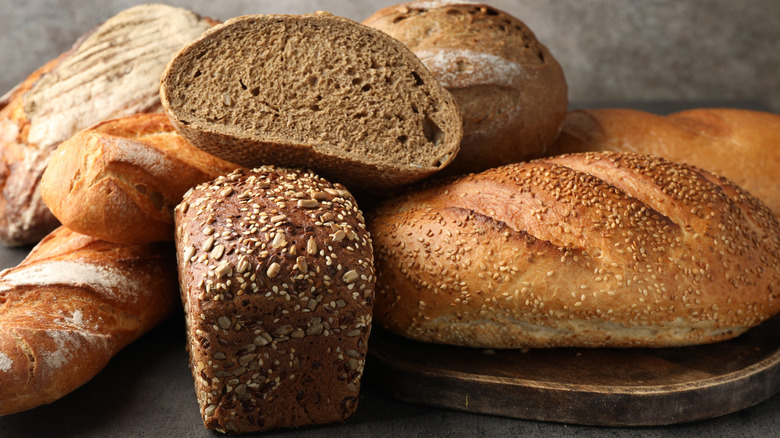 Different freshly baked bread loafs on grey table