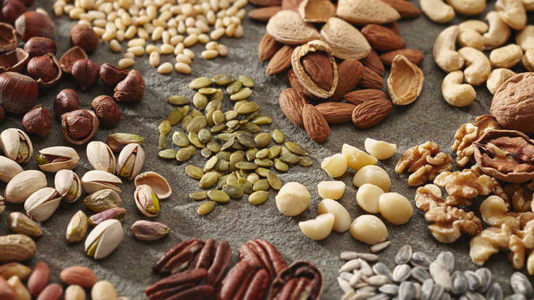 Piles of various nuts and seeds on stone surface