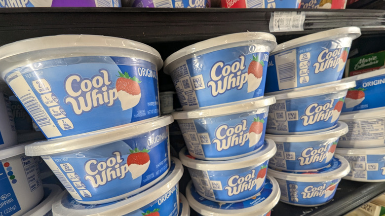 Containers of Cool Whip on grocery shelf.