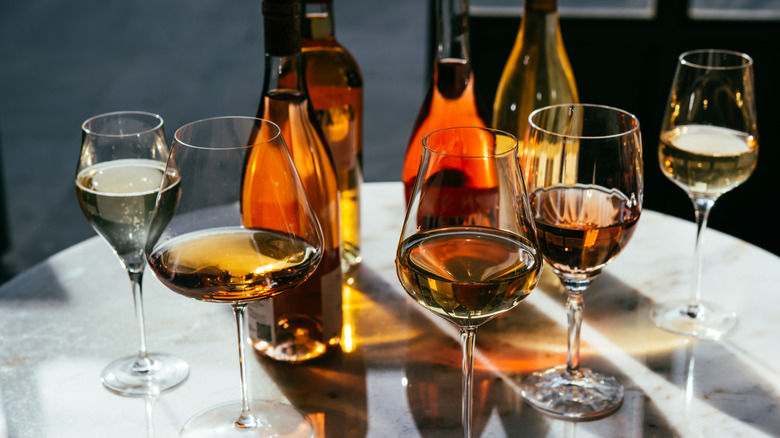 Various wine bottles and glasses on table