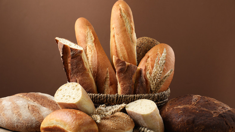 assorted bread products in a basket and on a table