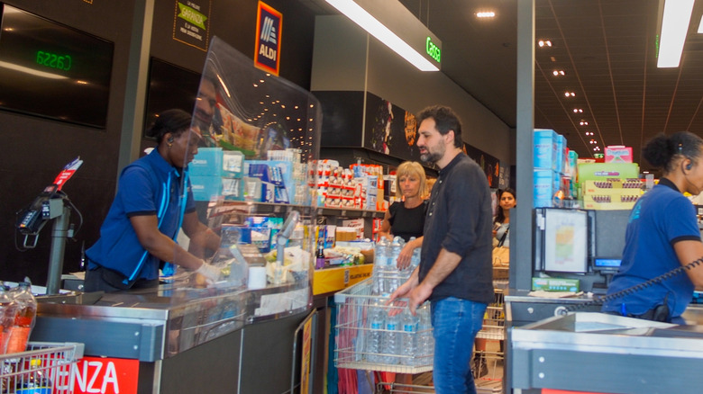 Shoppers with full carts at the cashier in Aldi
