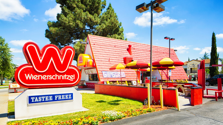 Wienerschnitzel Hot Dog restaurant with entrance sign in front of blue sky