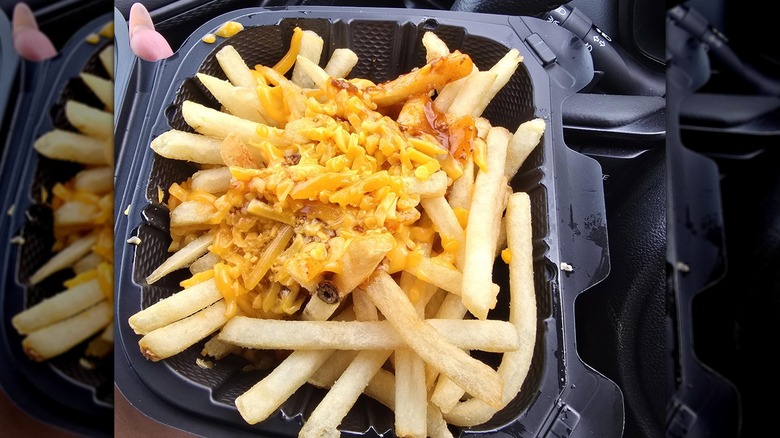Mirrored image of chili cheese fries in black takeout container
