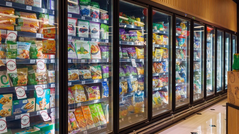 Interior view of huge glass fridge with various brand frozen foods in Mercato grocery store.