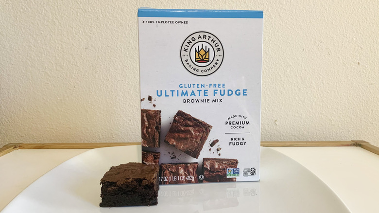 King Arthur Gluten Free Ultimate Fudge Brownie Mix box alongside a baked brownie