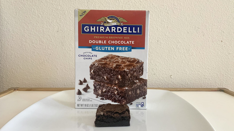 Ghirardelli Gluten Free Double Chocolate Brownie Mix box alongside a baked brownie