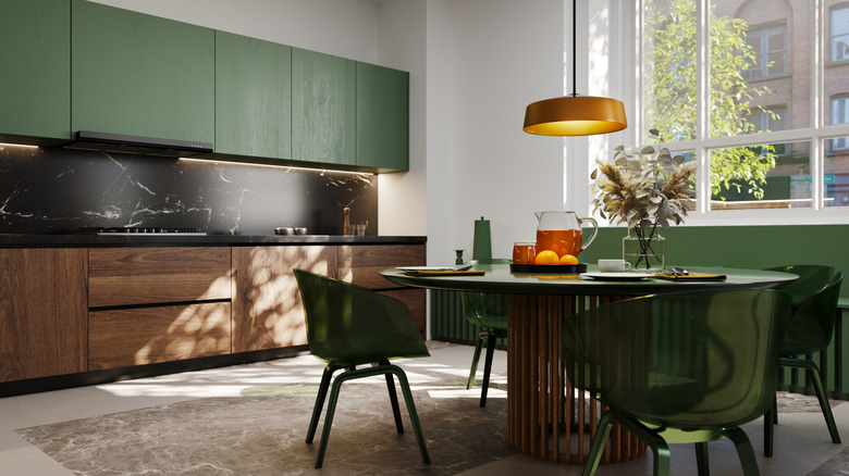Kitchen in dark green and wood with green lucite chairs