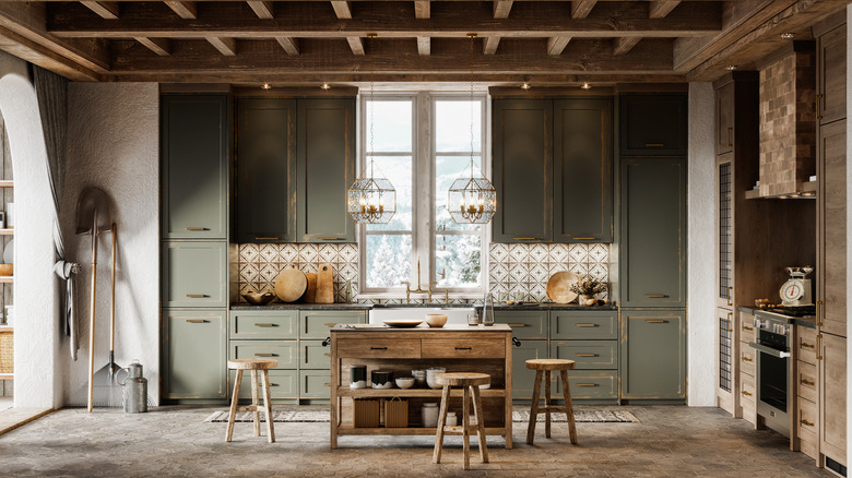 rustic, farmhouse kitchen with green cabinets and log ceiling