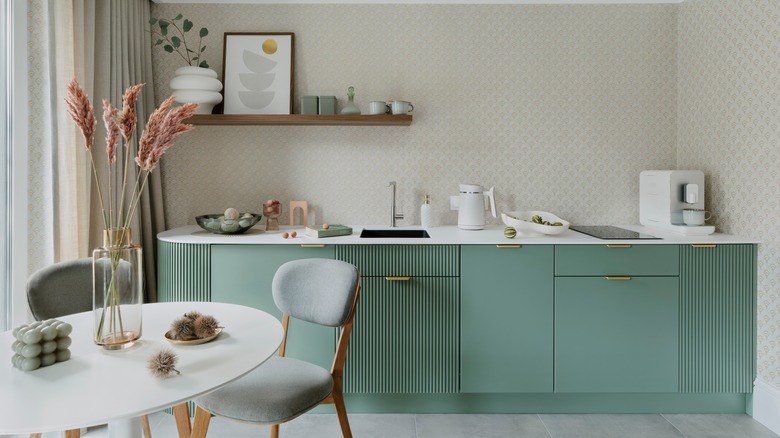 Rounded kitchen island with small table, two chairs in neutral green decor