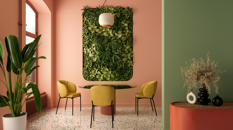 dining room with coral, green walls, yellow chairs and living wall
