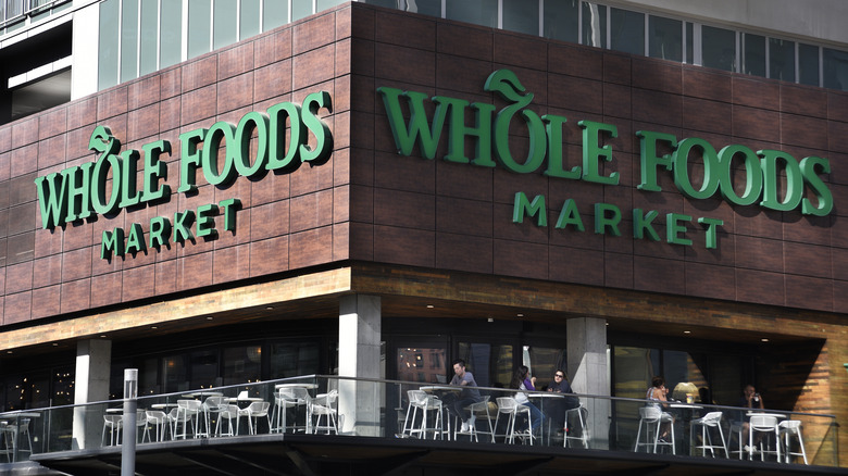 Exterior of Whole Foods corner of building with tables on patio