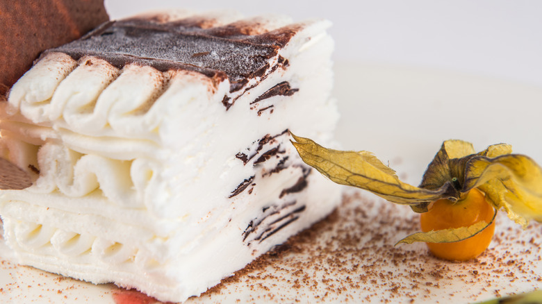 Closeup of a piece of Viennetta frozen cake with a gooseberry on the side