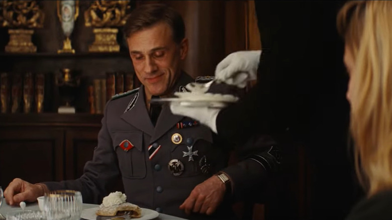 hans lander being served strudel with cream in inglorious basterds