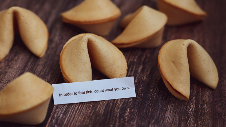 Fortune cookie with fortune card on a wooden table