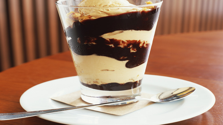 Hot fudge sundae with vanilla ice cream in a glass cup