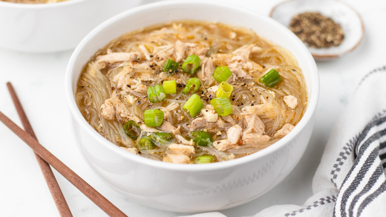 Bowl of Hawaiian chicken long rice soup, garnished with chopped green onions