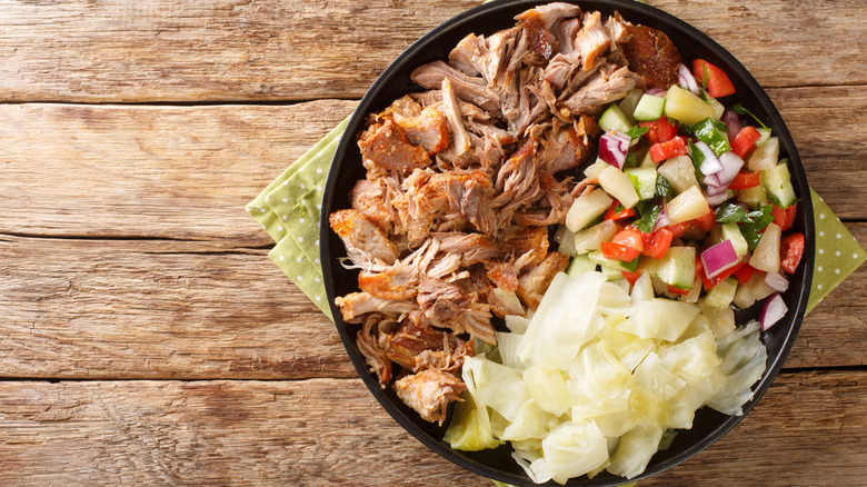 Bowl of Hawaiian kalua pork with steamed cabbage and fresh salad