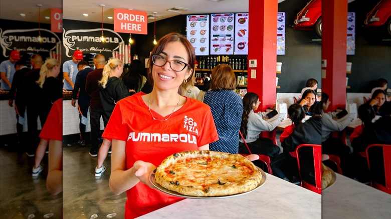 Pummarola waitress holding Margherita pizza
