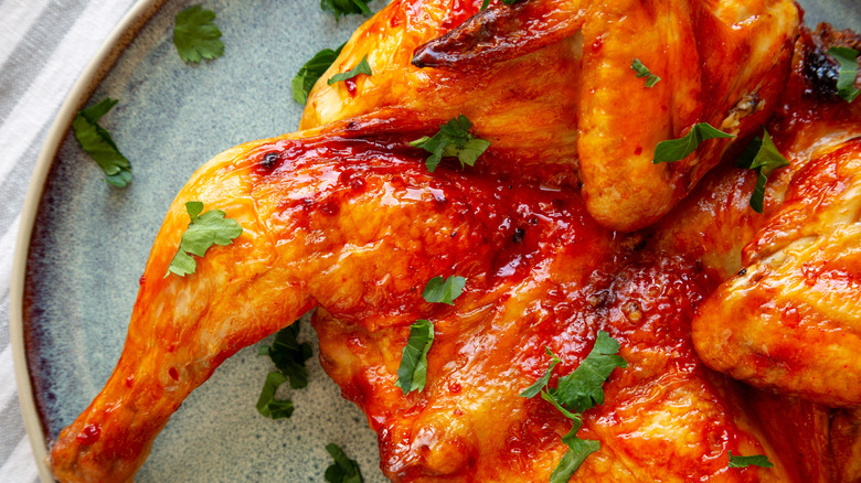 Spatchcocked chicken with peri peri sauce and parsley on top