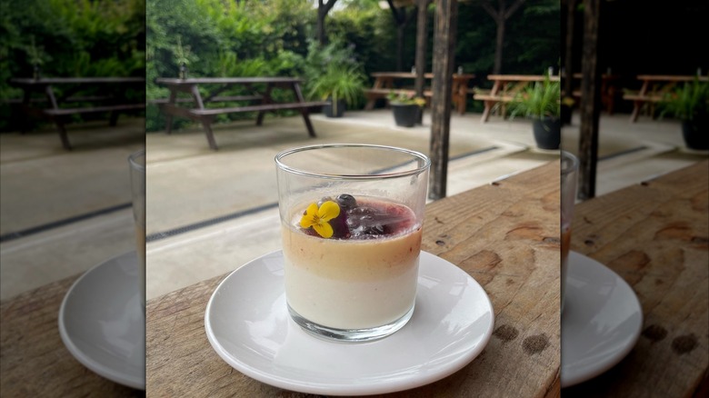 Glass full of carrageen moss pudding topped with flower and fruit
