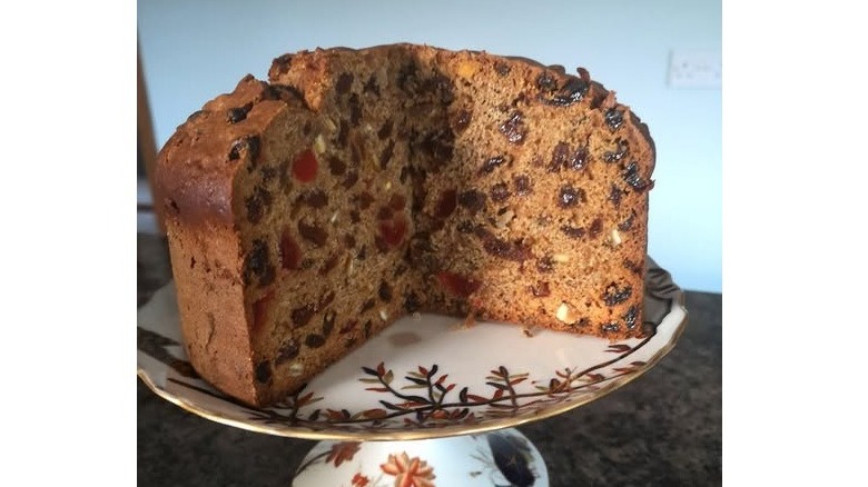 Large circular Irish port cake sliced open to show dried fruits and cherries inside