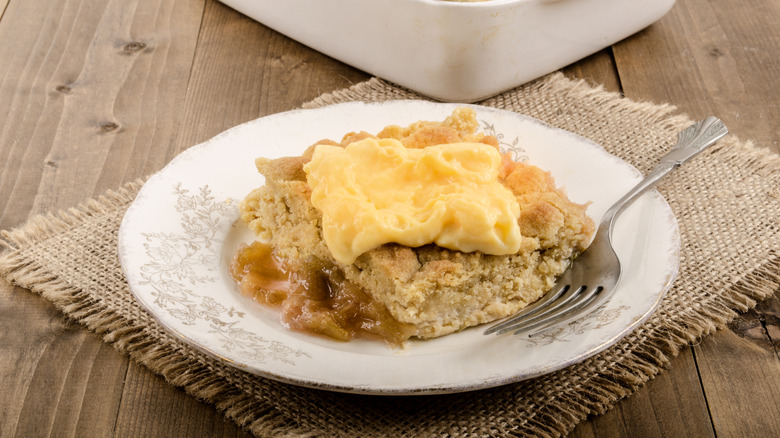 Square of rhubarb crumble topped with custard