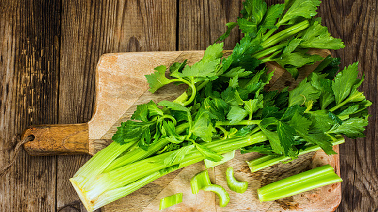 fresh celery on a wooden cutting board