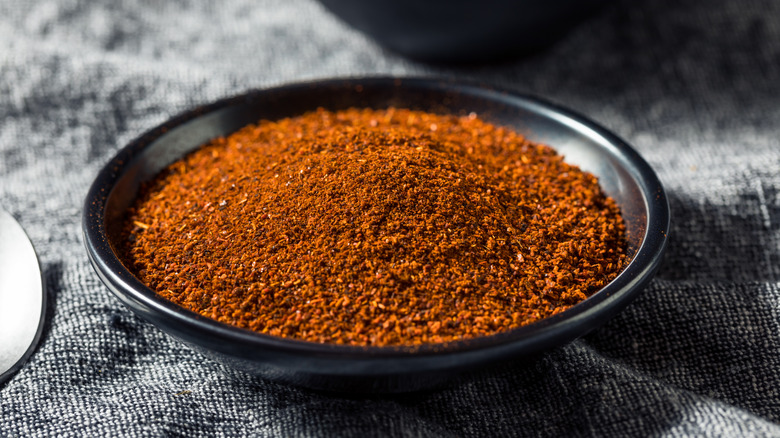 smoked paprika powder in a black ceramic bowl