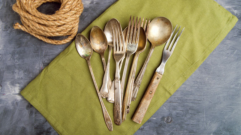 Mismatched cutlery placed on a green napkin