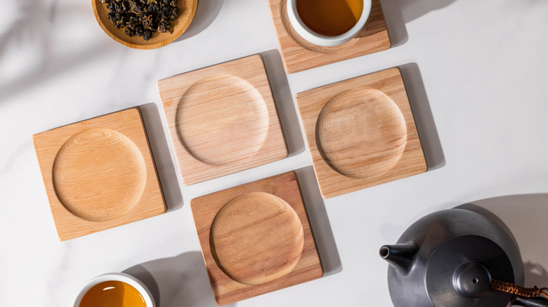 Set of five square wooden coasters with a cup of tea