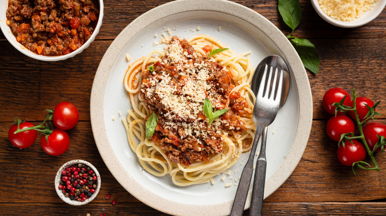 Plate of spaghetti bolognese, garnished with Parmesan cheese
