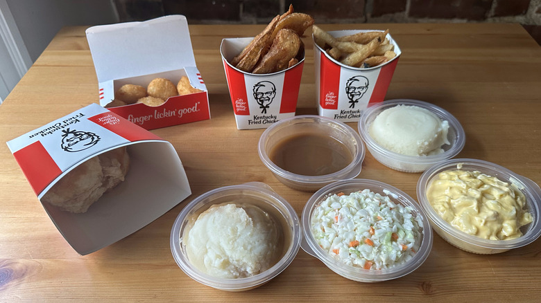 Various KFC side dishes on wooden table