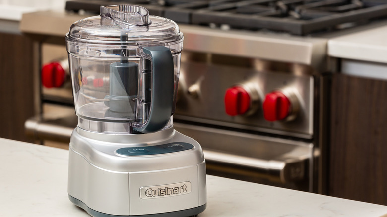 Cuisinart food processor standing on counter in front of oven