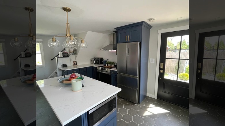 Modern kitchen with navy cabinets and black hexagon tiled flooring