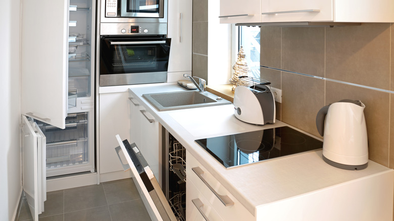Cramped kitchen layout with open appliance doors