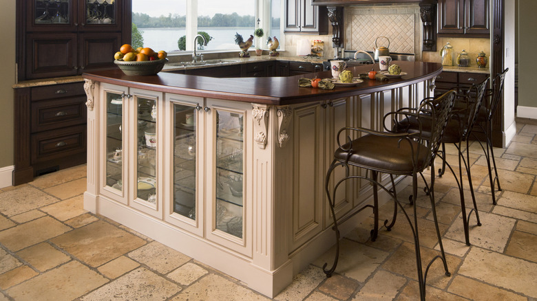 Large kitchen island with glass fronted cabinets for storage
