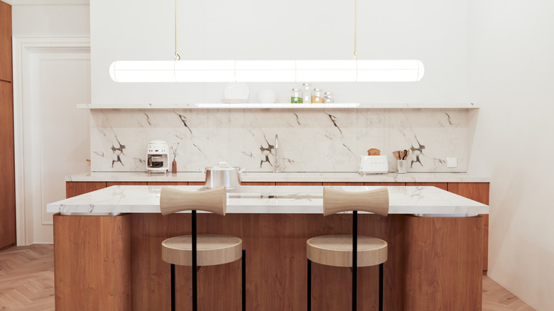 Modern sleek kitchen with wooden cabinets and chairs