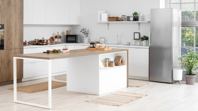 Bright kitchen with central island white base and wooden countertop