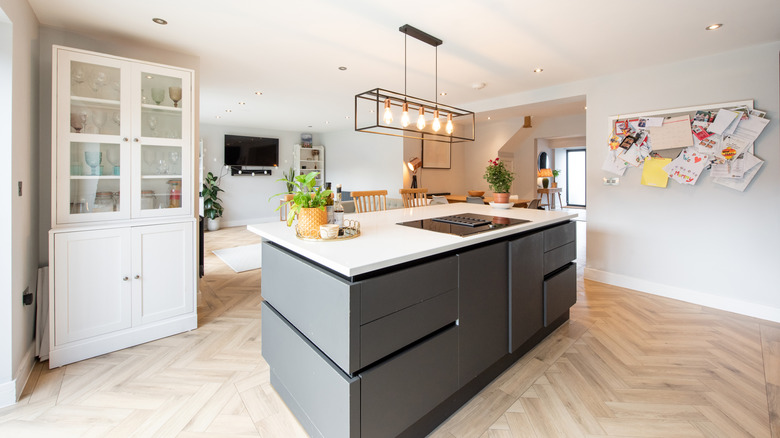 Open plan kitchen with a grey island and white countertops