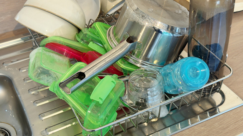 Various kitchen items drying in dish rack next to sink
