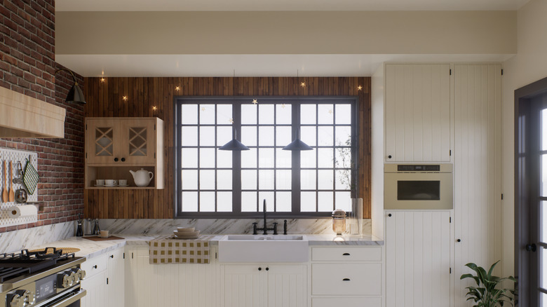 L-shaped kitchen with brick walls and bright cabinetry