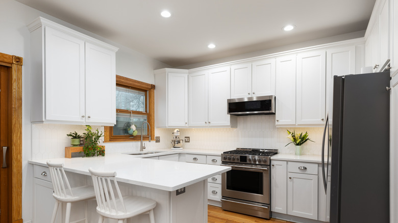 Bright kitchen with white peninsula table and wooden flooring