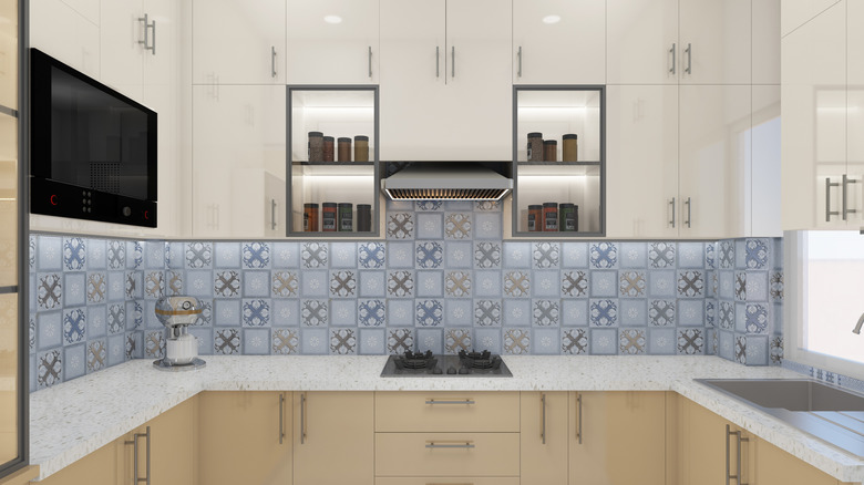 U-shaped kitchen with patterned backsplash and neutral cabinetry