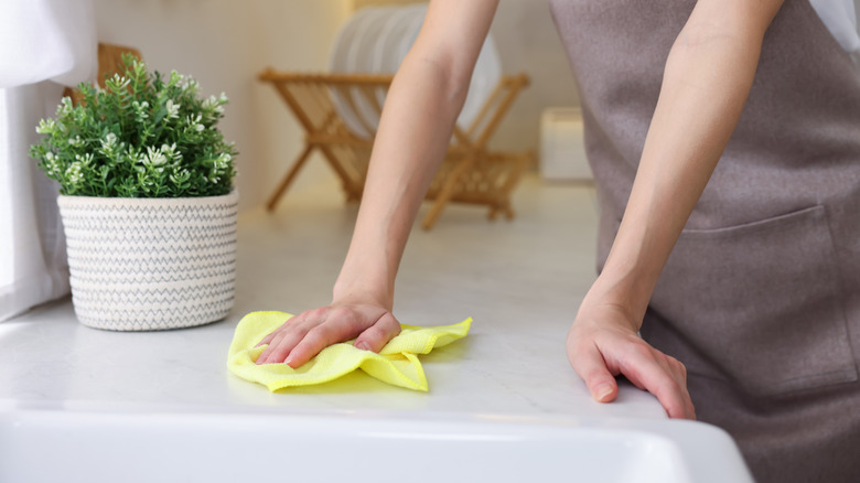 Woman wiping down kitchen countertop
