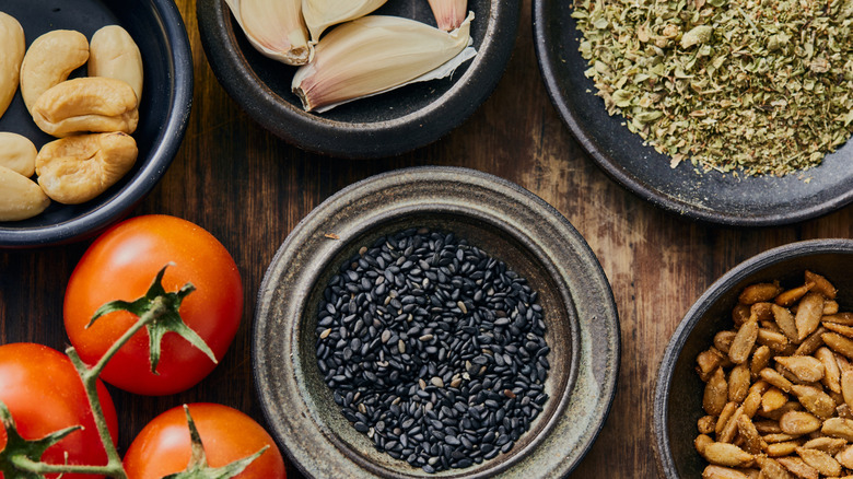 Various spices and seasonings laid out on a wooden table in preparation for cooking