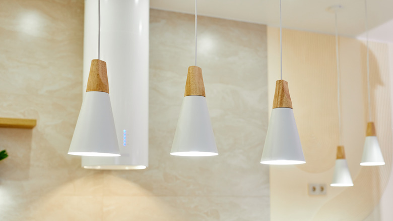 Minimalist hanging pendants against light-colored tiles
