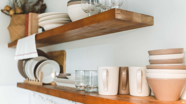 Close-up of wooden floating shelves stacked with dishware