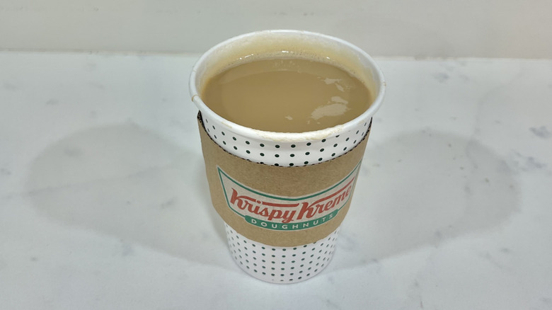 Krispy Kreme hot original glazed latte in to-go cup.
